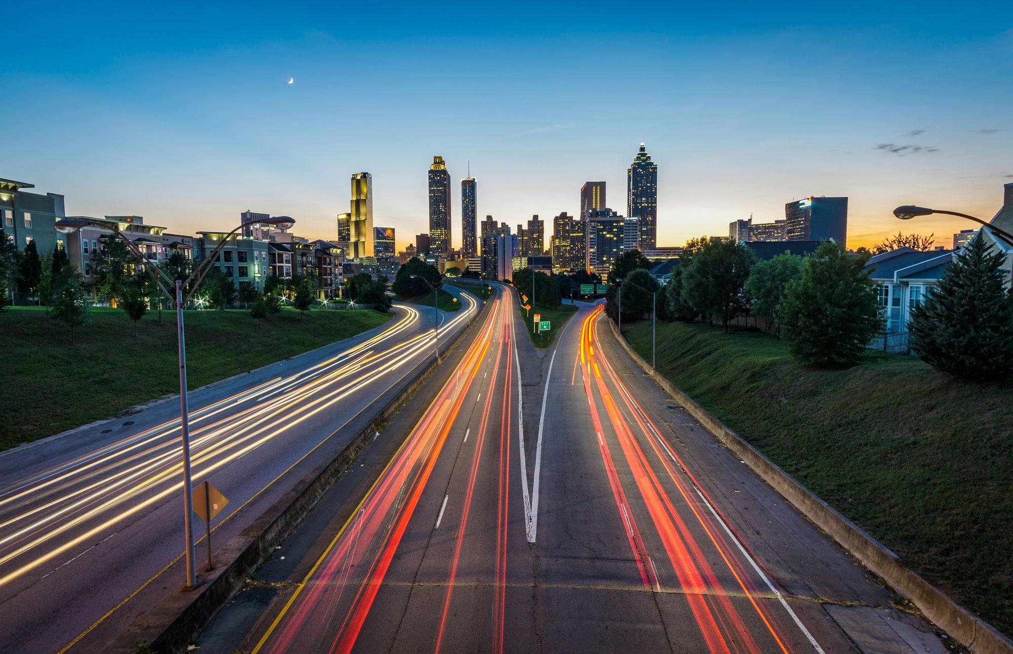 Downtown Atlanta skyline at dusk from the Jackson Street Bridge, light trails streaking down the connector